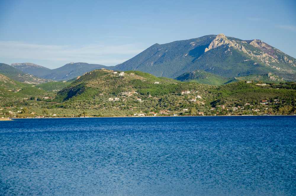 lake vouliagmenis with mountain on other side and houses