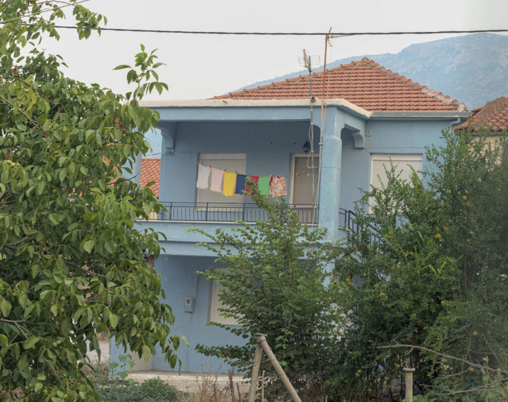 colourful clothing hanging on a line to dry in front of blue house