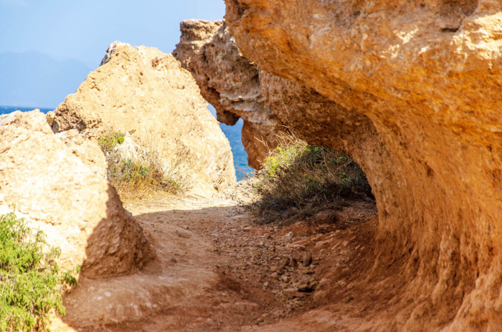 rock and earth geological formation with a path to the sea