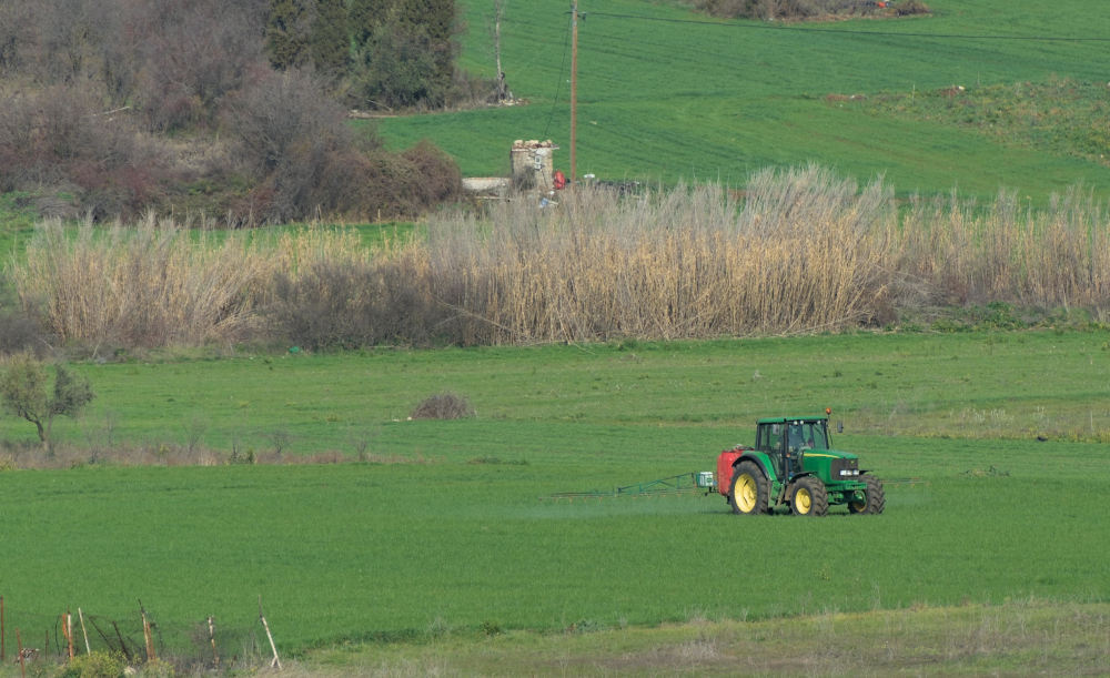 john deere tractor working in field near exarchos, greece